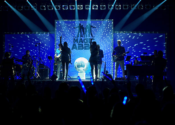 "The Magic of ABBA Bandmitglieder bei einem Live-Auftritt mit Disco-Lichtern"